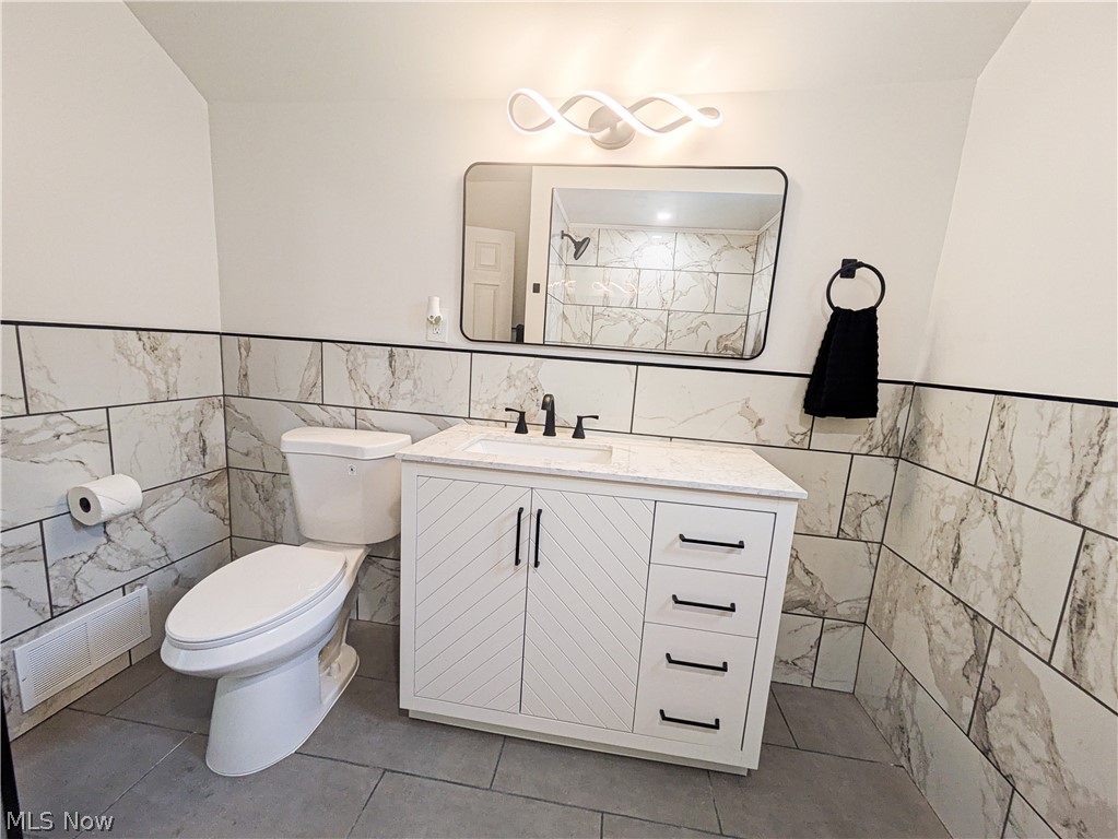 3554 Ludgate Road Shaker Heights, OH 44120 - Photo 38 of 50 White vanity with chevron-patterned cabinet doors, matte black hardware, and an integrated white countertop and sink