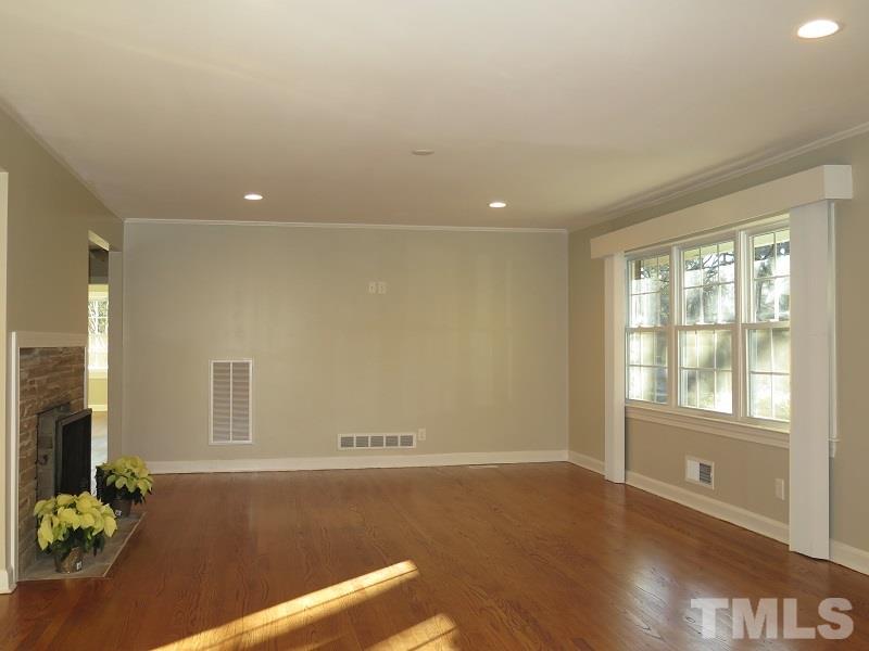 711 St George Road Raleigh, NC 27610 - Photo 2 of 19 an empty room with wooden floor and windows