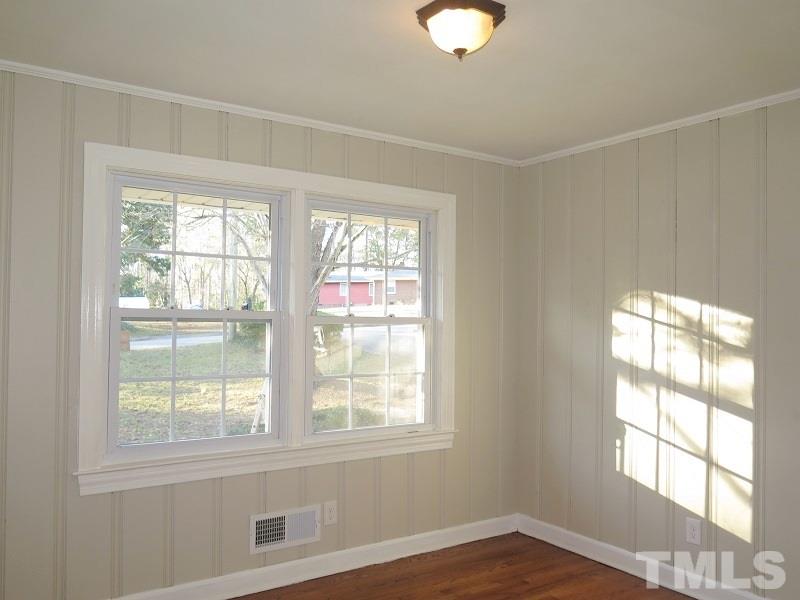 711 St George Road Raleigh, NC 27610 - Photo 13 of 19 an empty room with wooden floor and windows