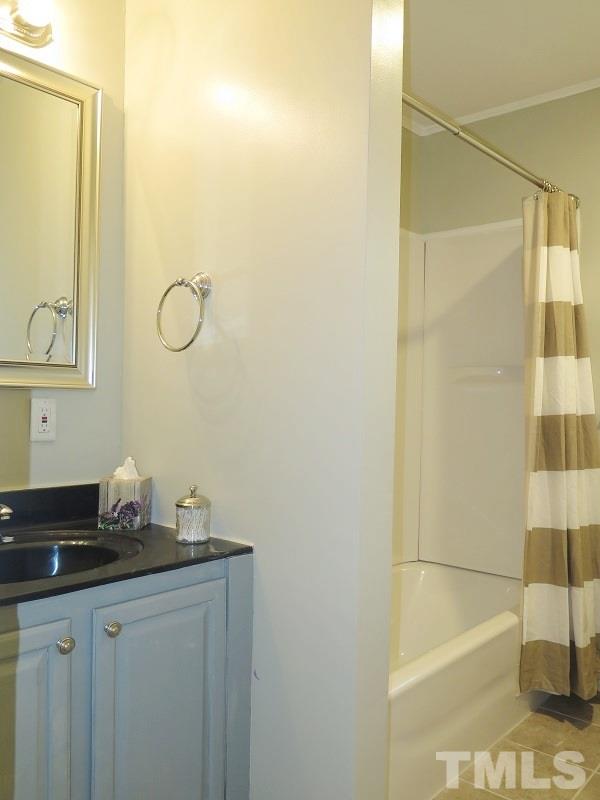 711 St George Road Raleigh, NC 27610 - Photo 15 of 19 a bathroom with a granite countertop sink a mirror and shower