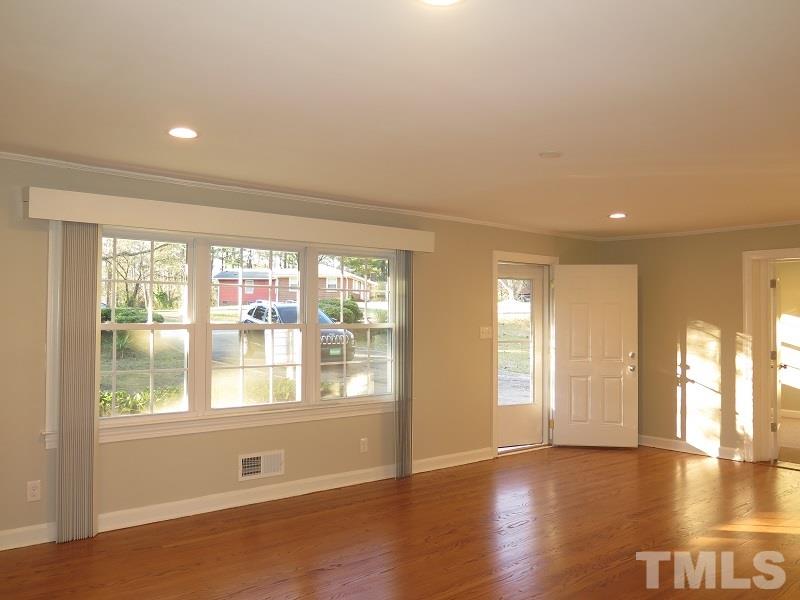 711 St George Road Raleigh, NC 27610 - Photo 4 of 19 a view of empty room with wooden floor and fan
