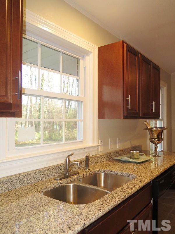 711 St George Road Raleigh, NC 27610 - Photo 8 of 19 a kitchen with granite countertop a sink window and cabinets