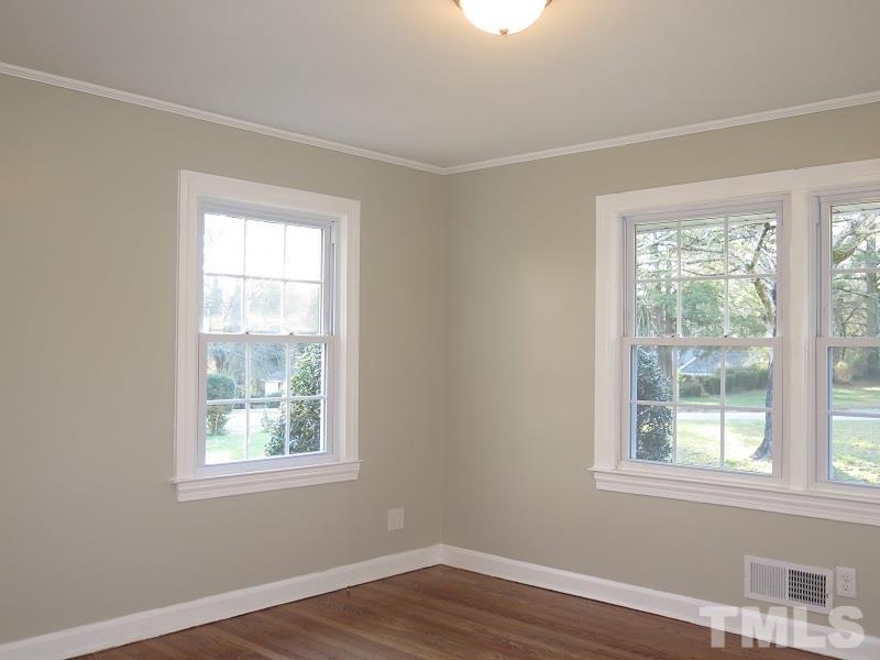 711 St George Road Raleigh, NC 27610 - Photo 10 of 19 an empty room with wooden floor and windows