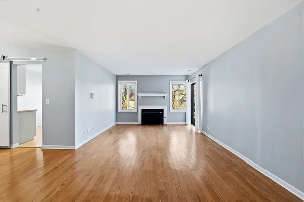 a view of empty room with wooden floor and fireplace