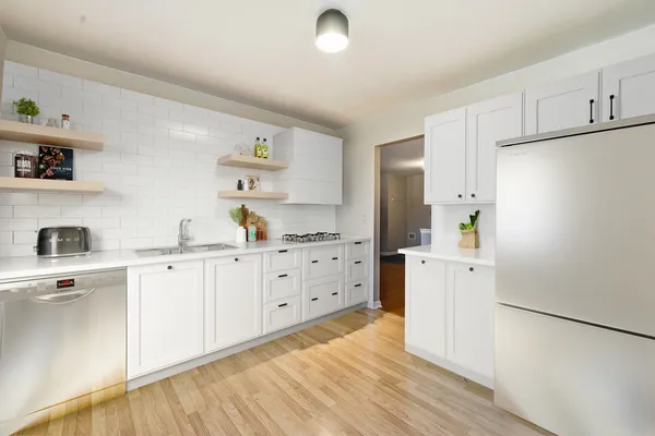 a kitchen with cabinets oven and a dishwasher with wooden floor