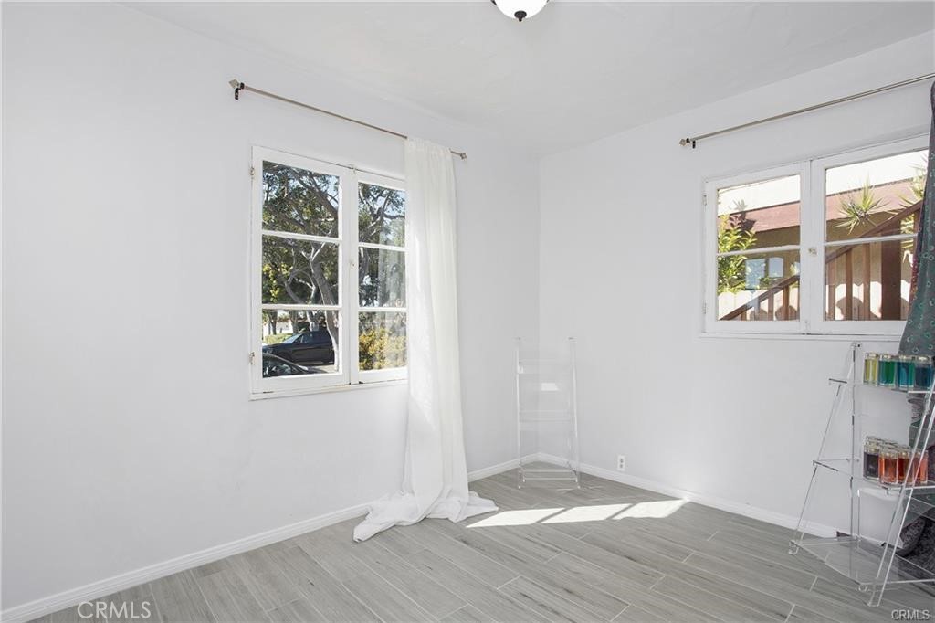 251 Avenida Del Mar, Unit A San Clemente, CA 92672 - Photo 9 of 15 an empty room with wooden floor and windows