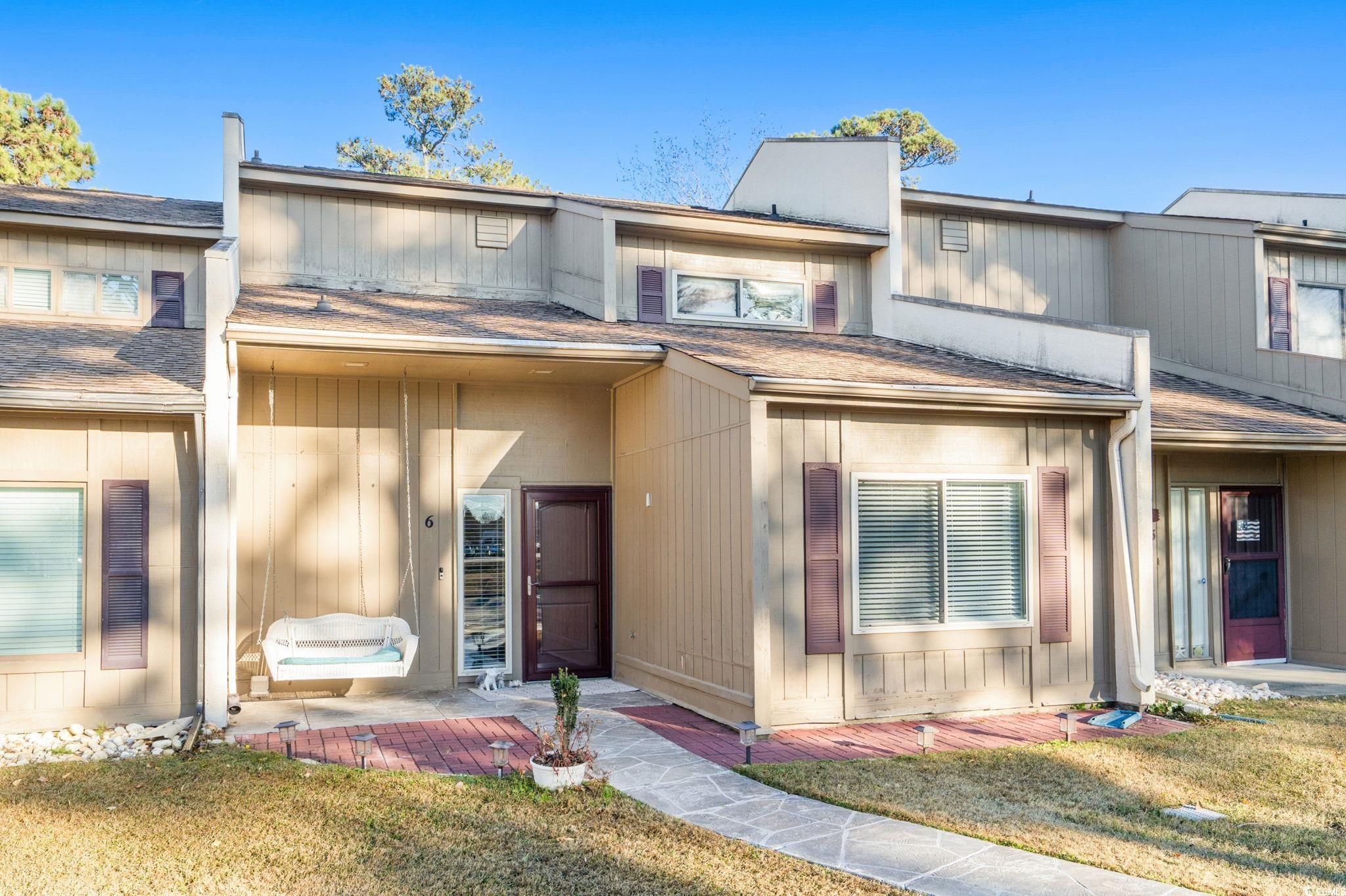 View of front facade with a front yard and roof with shingles