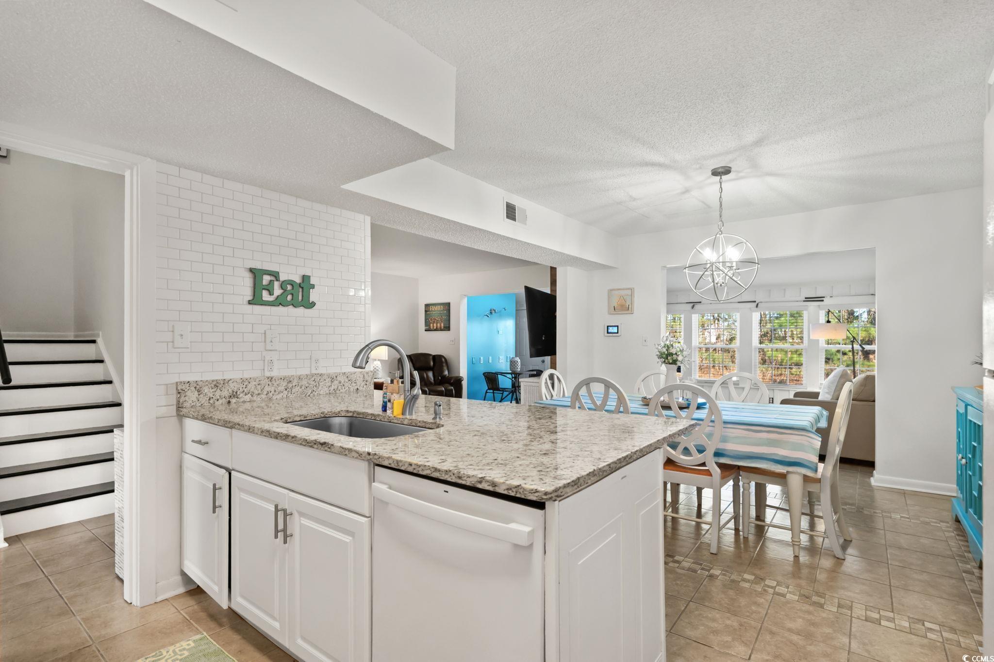 500 Eagle Way, Unit 6 Little River, SC 29566 - Photo 12 of 38 Kitchen with dishwasher, light stone countertops, white cabinetry, light tile patterned floors, and a textured ceiling