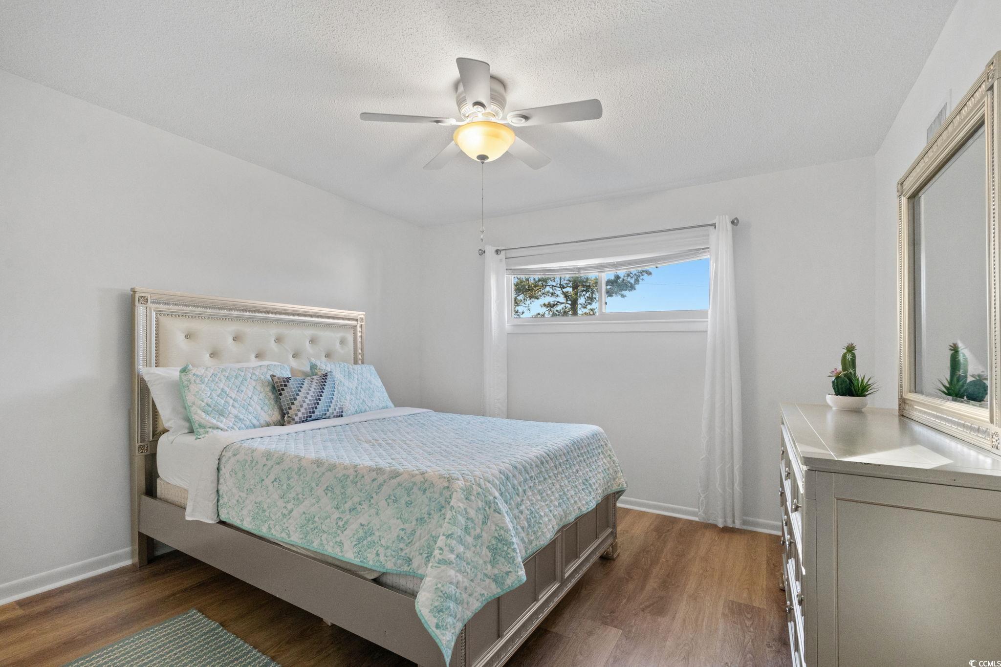500 Eagle Way, Unit 6 Little River, SC 29566 - Photo 15 of 38 Bedroom with wood finished floors, a ceiling fan, and a textured ceiling