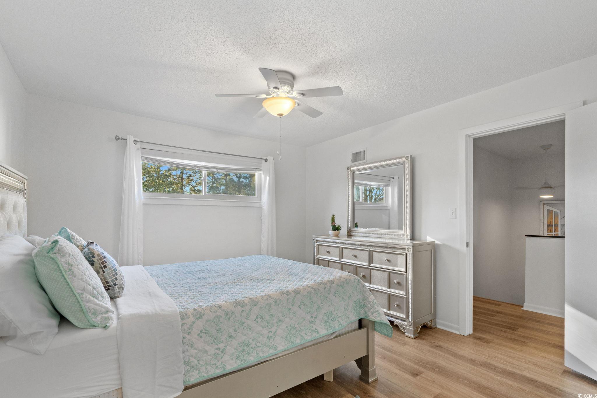 500 Eagle Way, Unit 6 Little River, SC 29566 - Photo 16 of 38 Bedroom featuring wood finished floors, ceiling fan, and a textured ceiling