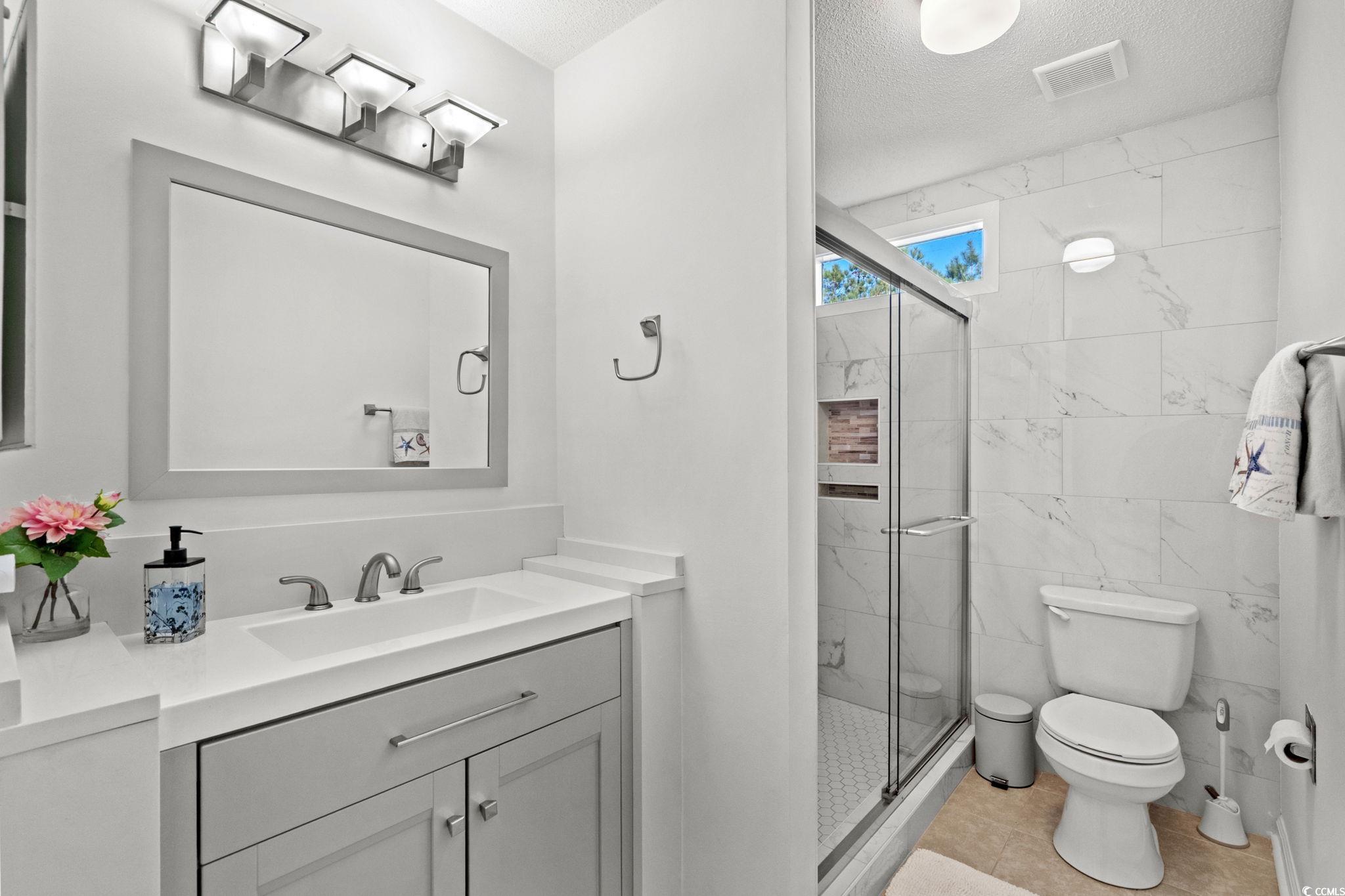 500 Eagle Way, Unit 6 Little River, SC 29566 - Photo 17 of 38 Full bath with vanity, a marble finish shower, and a textured ceiling