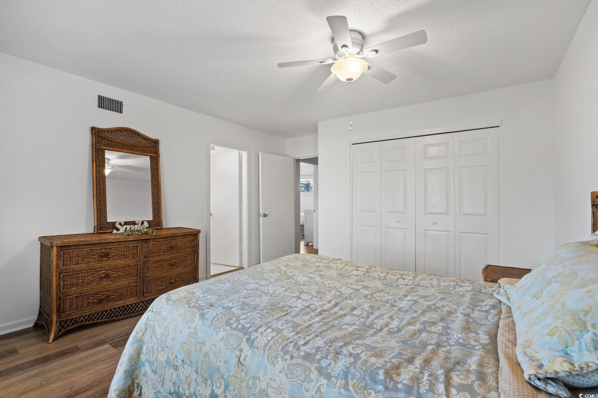 500 Eagle Way, Unit 6 Little River, SC 29566 - Photo 18 of 38 Bedroom with dark wood finished floors, a closet, and a ceiling fan