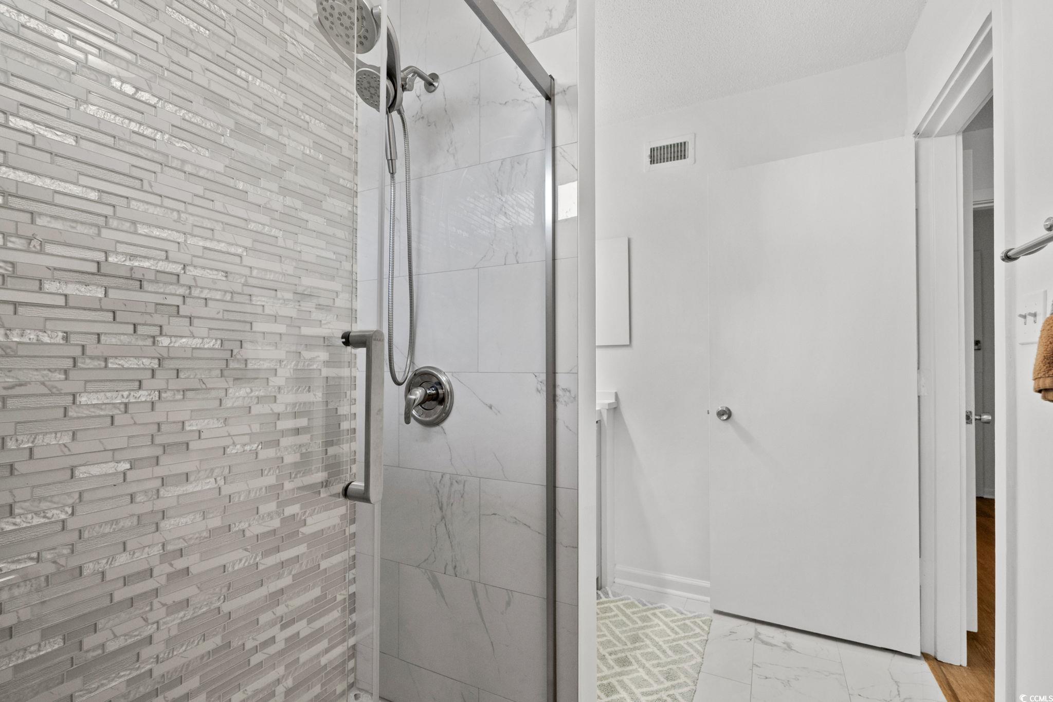 500 Eagle Way, Unit 6 Little River, SC 29566 - Photo 20 of 38 Bathroom featuring a shower stall and light marble finish flooring