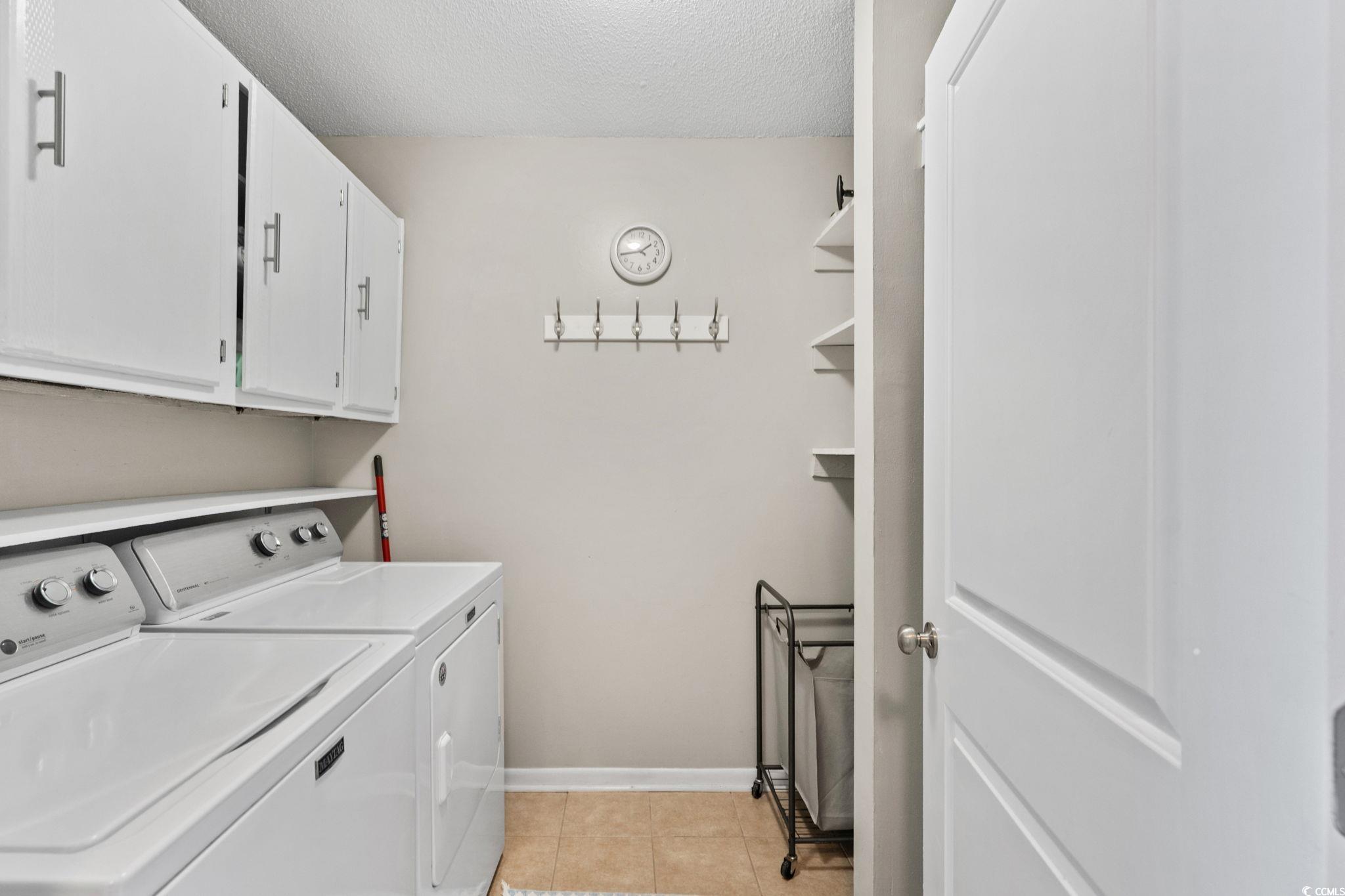 500 Eagle Way, Unit 6 Little River, SC 29566 - Photo 22 of 38 Washroom featuring a textured ceiling, washer and dryer, light tile patterned floors, and cabinet space
