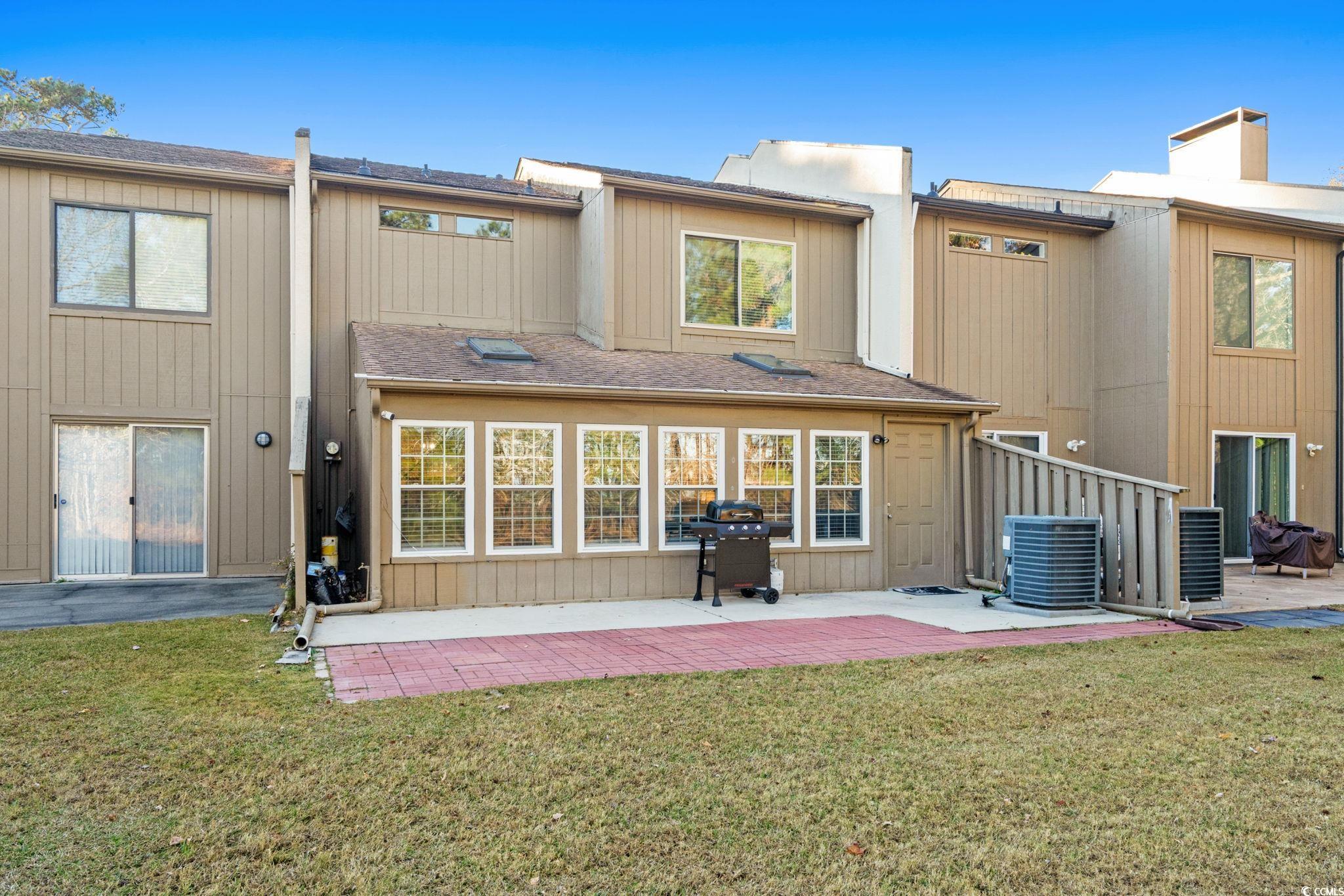 500 Eagle Way, Unit 6 Little River, SC 29566 - Photo 25 of 38 Back of property featuring a patio, roof with shingles, and a lawn