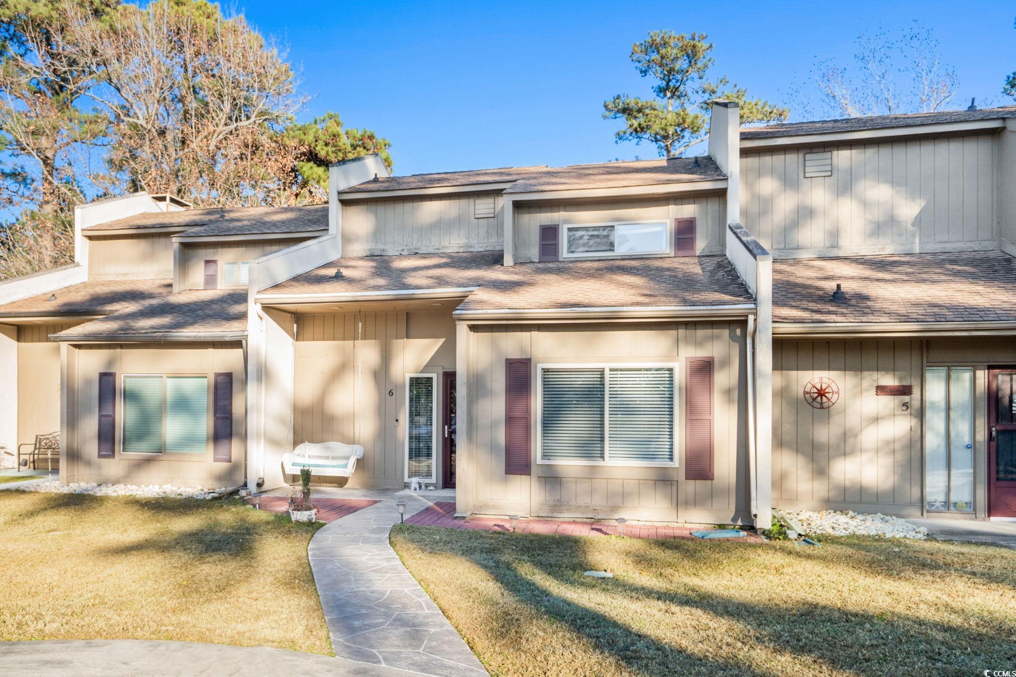 500 Eagle Way, Unit 6 Little River, SC 29566 - Photo 26 of 38 View of front facade with a shingled roof, a chimney, and a front yard