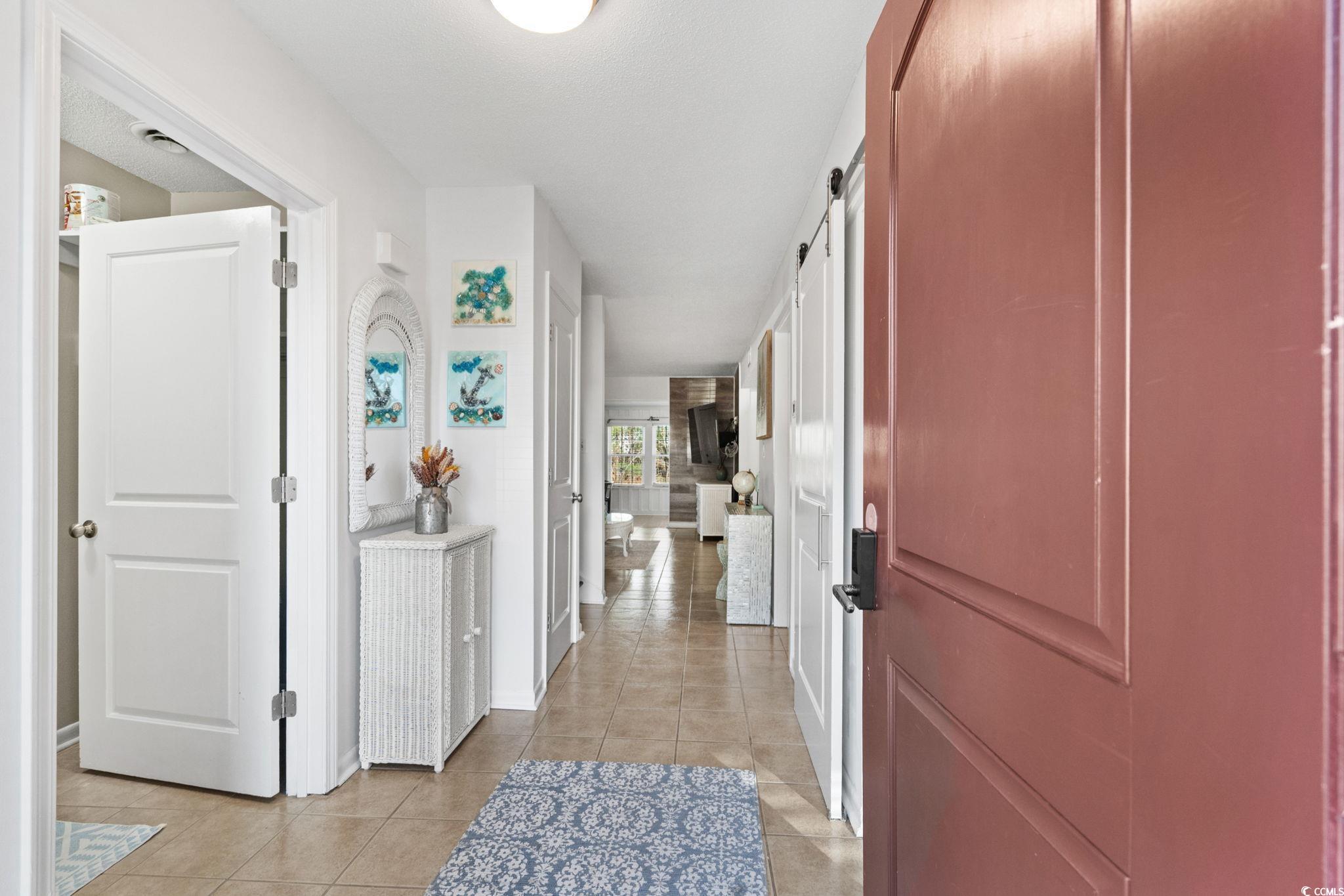 500 Eagle Way, Unit 6 Little River, SC 29566 - Photo 3 of 38 Corridor featuring a barn door and light tile patterned floors