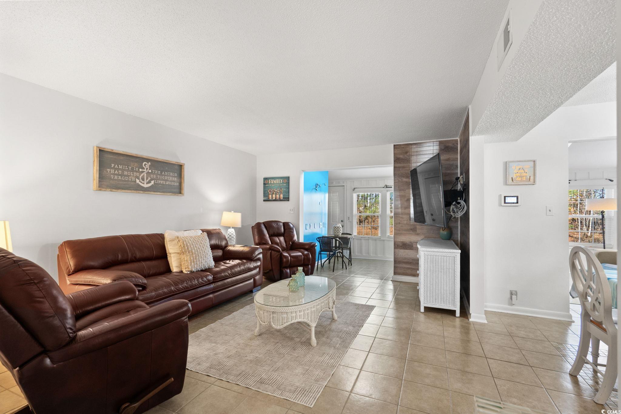 500 Eagle Way, Unit 6 Little River, SC 29566 - Photo 4 of 38 Living area with light tile patterned flooring and a textured ceiling