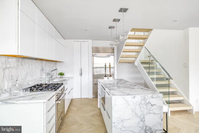 a kitchen with granite countertop white cabinets and stainless steel appliances