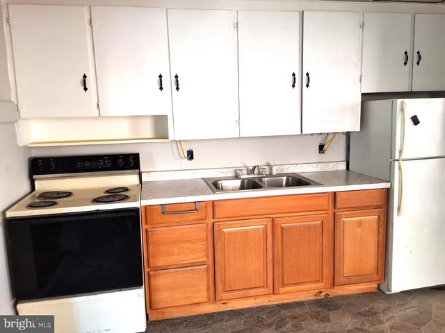 a kitchen with stainless steel appliances granite countertop a refrigerator a stove and white cabinets