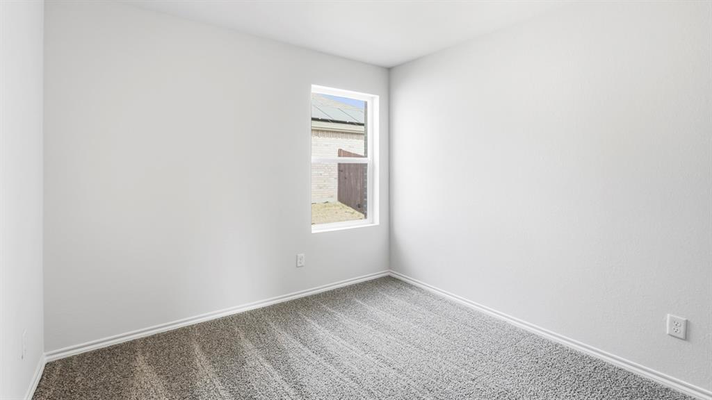 3519 Spring Time Street Forney, TX 75126 - Photo 12 of 37 Neutral tone walls, grey textured carpeting, white baseboards, and a single pane window