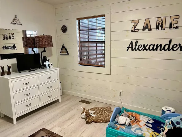 a bedroom with a dresser and a window