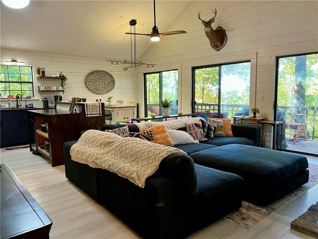 a living room with couches a chandelier with a large air conditioner and a large window