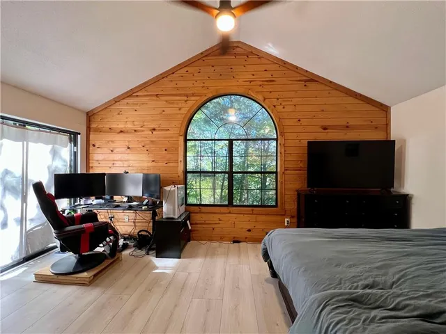 a bedroom with a large bed and glass windows