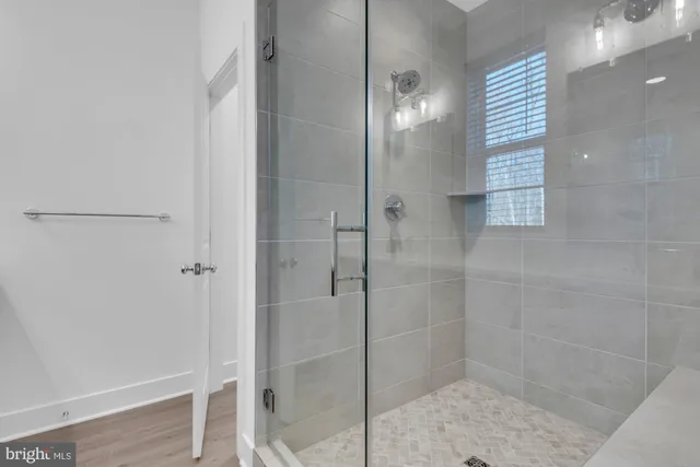 a view of a hallway with wooden floor and closet