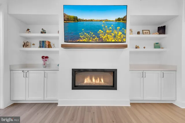 a kitchen with kitchen island a refrigerator a stove a sink and a dining table with wooden floor