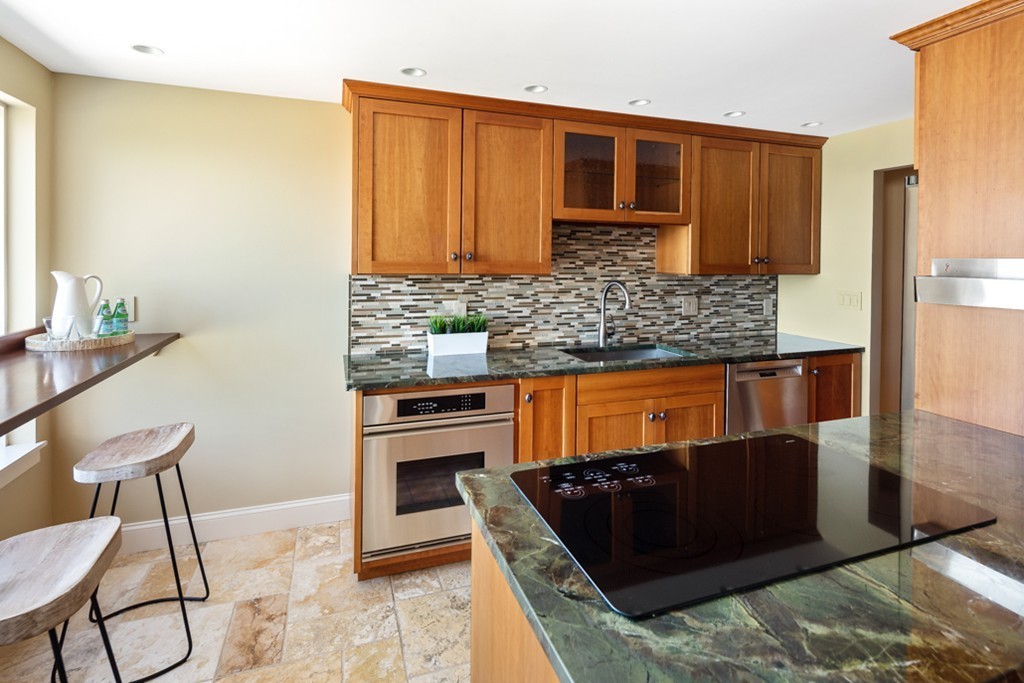1 Commodore Court, Unit 405 Hull, MA 02045 - Photo 11 of 26 a kitchen with stainless steel appliances granite countertop a stove a sink and a refrigerator