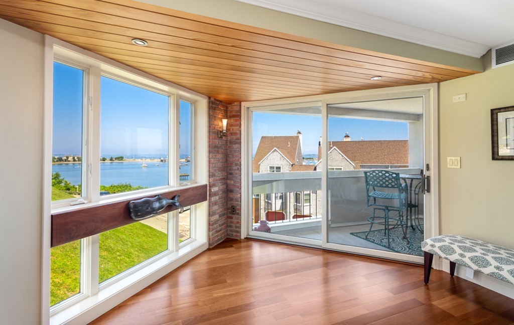 1 Commodore Court, Unit 405 Hull, MA 02045 - Photo 4 of 26 a view of a large room with wooden floor and windows