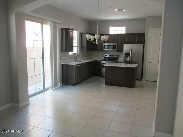 a large kitchen with a stove a sink and a refrigerator