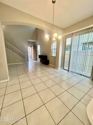a view of a livingroom with a flesh screen tv and stairs