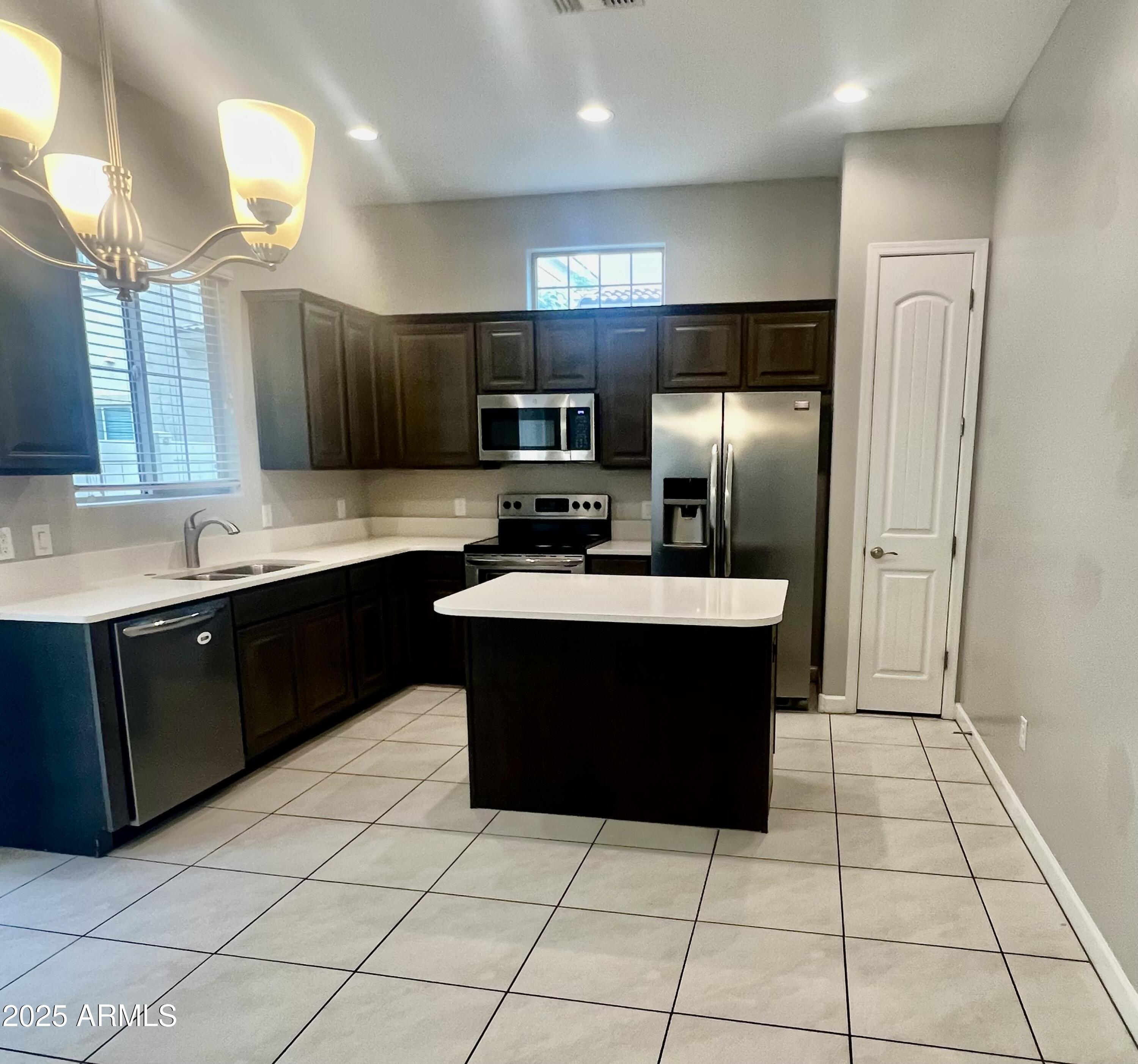 1367 South Country Club Drive, Unit 1153 Mesa, AZ 85210 - Photo 40 of 48 a kitchen with a sink counter top space cabinets and stainless steel appliances