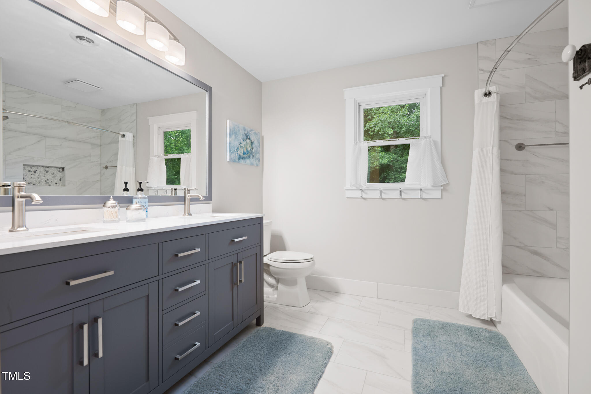 8608 Valley Brook Drive Raleigh, NC 27613 - Photo 42 of 74 a bathroom with a double vanity sink a toilet and a shower