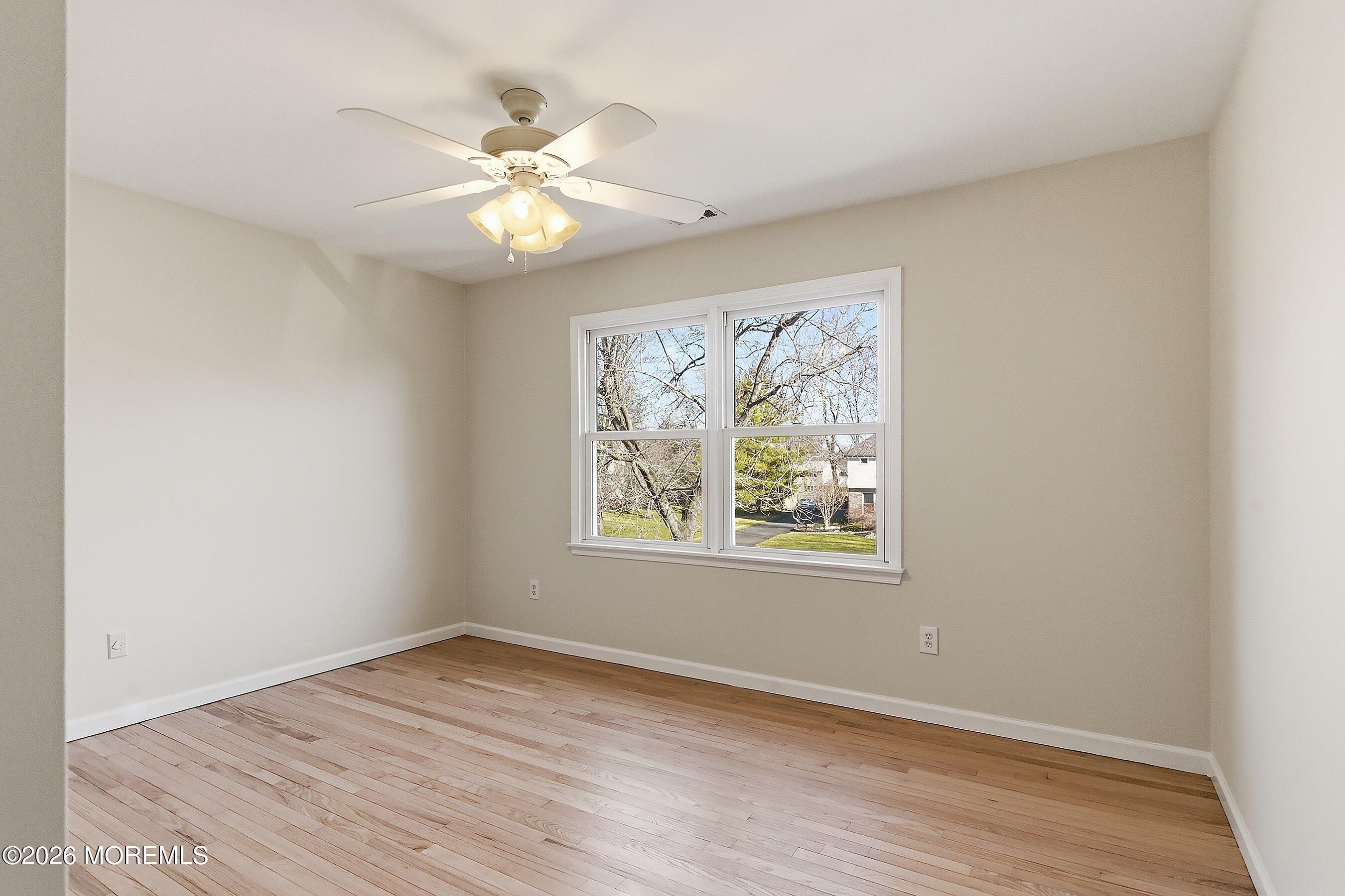 7 Shire Way Middletown, NJ 07748 - Photo 28 of 61 an empty room with wooden floor chandelier fan and windows