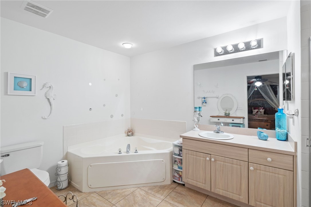 811 Abrams Boulevard Lehigh Acres, FL 33971 - Photo 12 of 22 a bathroom with a bathtub a sink and mirror