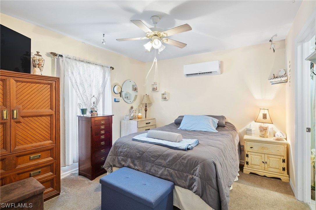 811 Abrams Boulevard Lehigh Acres, FL 33971 - Photo 13 of 22 a bedroom with a bed and a chandelier