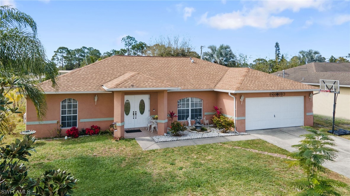 811 Abrams Boulevard Lehigh Acres, FL 33971 - Photo 2 of 22 a view of a house with garden and plants