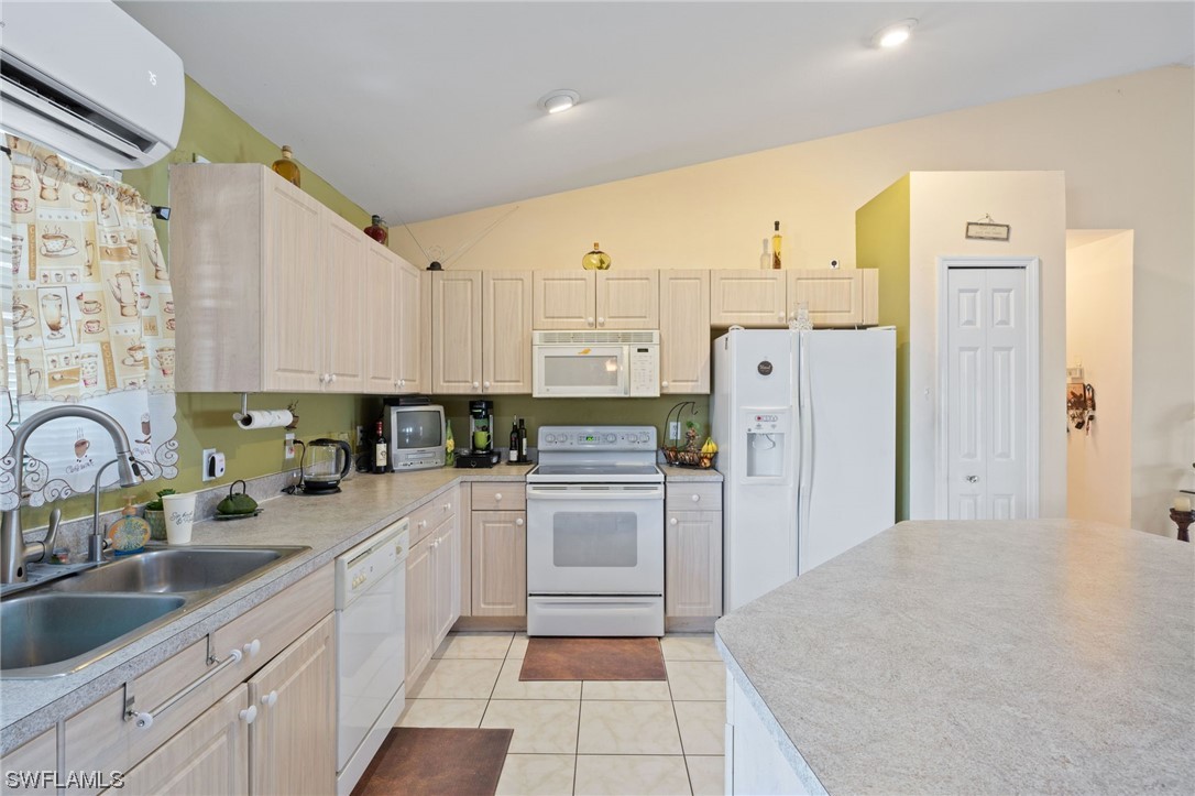 811 Abrams Boulevard Lehigh Acres, FL 33971 - Photo 7 of 22 a kitchen with a sink a refrigerator and cabinets