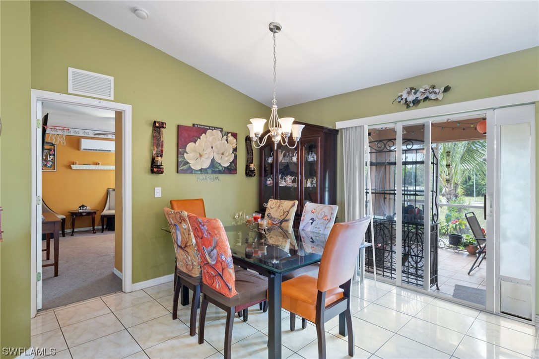 811 Abrams Boulevard Lehigh Acres, FL 33971 - Photo 8 of 22 a dining room with furniture a chandelier and a rug