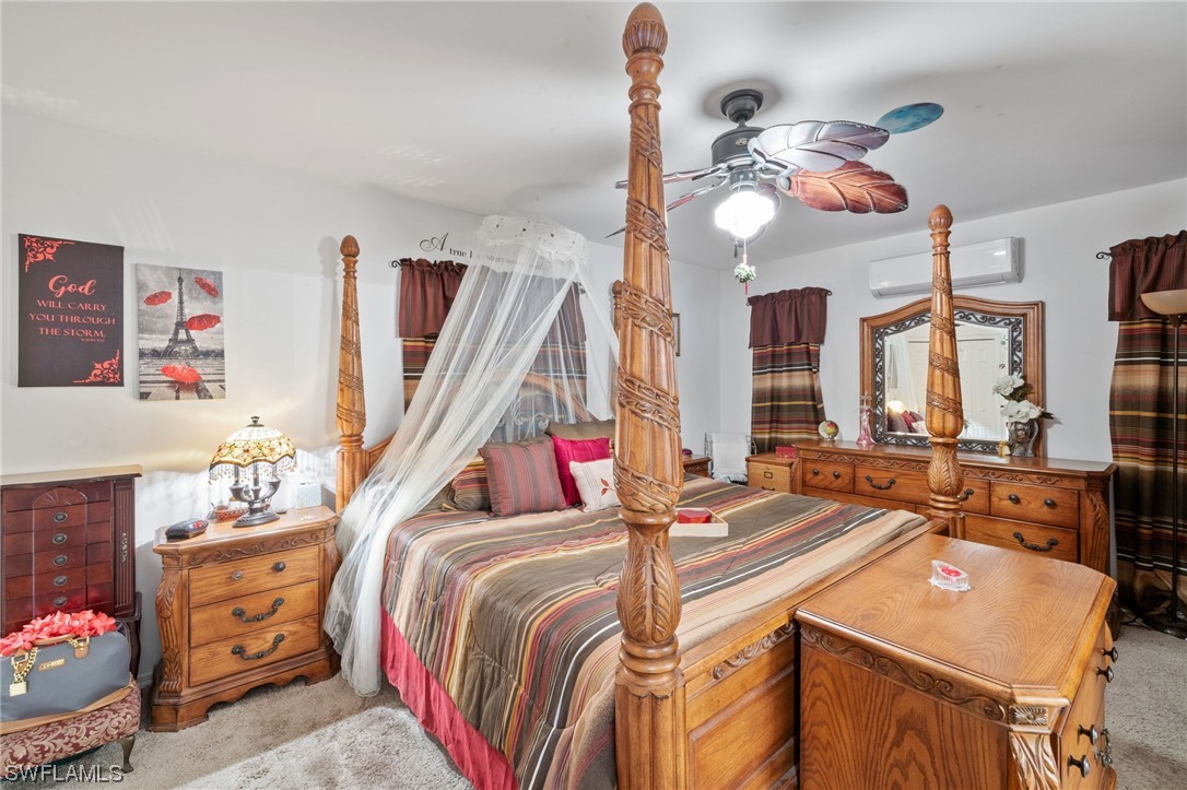 811 Abrams Boulevard Lehigh Acres, FL 33971 - Photo 10 of 22 a bedroom with a bed dresser and a large mirror