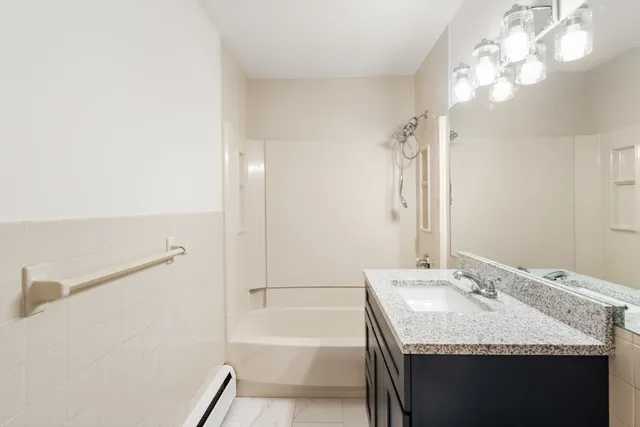 a bathroom with a granite countertop sink a toilet and bathtub