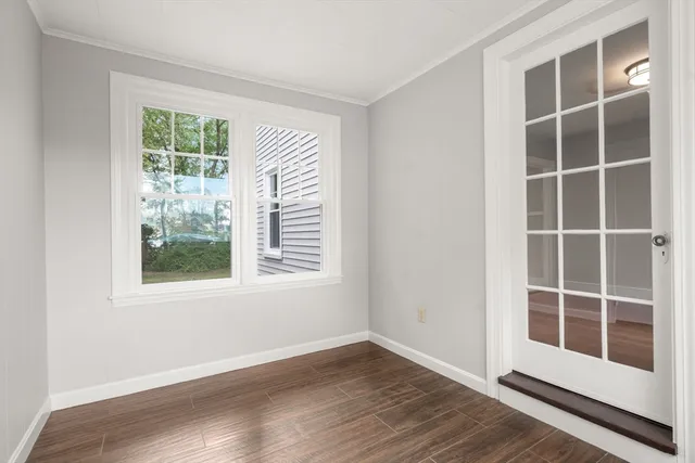 a view of empty room with wooden floor and windows