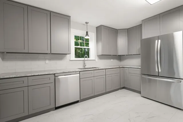 a kitchen with a refrigerator sink and cabinets