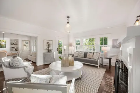 a living room with fireplace furniture and a chandelier