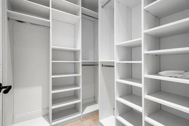 a view of walk in closet with empty racks
