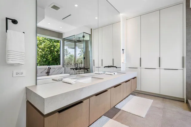 a bathroom with a sink and mirror with a shower