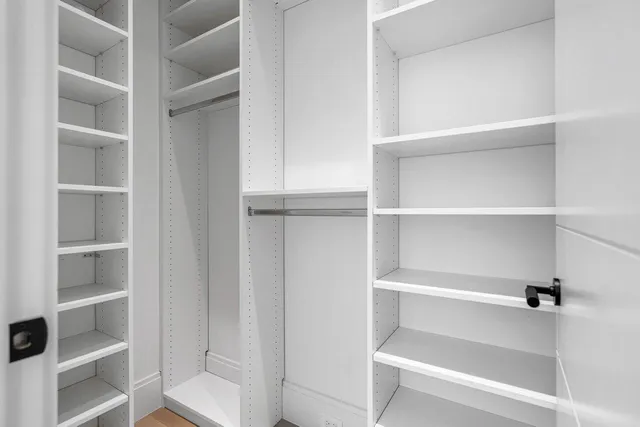 a view of walk in closet with empty racks